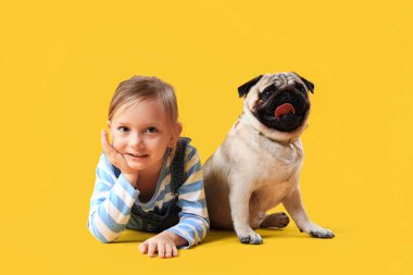 Sarı arka planda sevimli köpekli küçük kız.