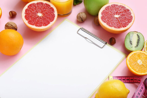 Composition with blank clipboard and healthy products on pink background, closeup
