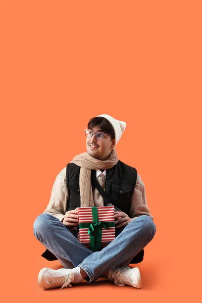 Hombre Joven Ropa Invierno Con Regalo Navidad Sentado Sobre Fondo —  Fotos de Stock