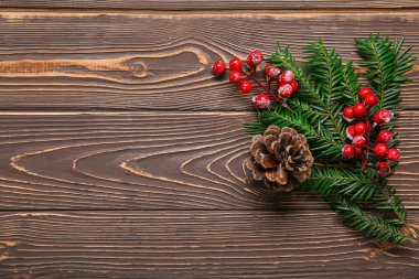 Köknar dalları, koni ve ahşap arka planda kırmızı böğürtlenli kompozisyon