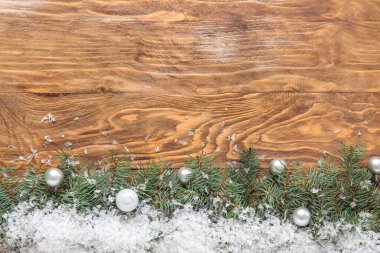 Köknar dalları, Noel topları ve ahşap zemin üzerinde kar olan kompozisyon