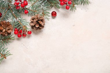 Açık arkaplanda köknar dalları, koniler ve kırmızı böğürtlenlerle Noel kompozisyonu