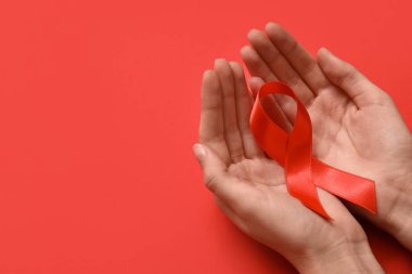Arka planda kırmızı kurdeleli bir kadın. AIDS Günü konsepti