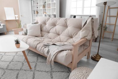 Loş oturma odasının içinde şık bir kanepe ve sehpa var.