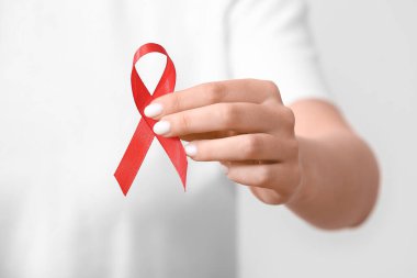 Beyaz arka planda kırmızı kurdeleli bir kadın. AIDS Günü konsepti