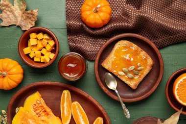 Kavanoz ve tost, yeşil ahşap arka planda balkabağı reçeli.