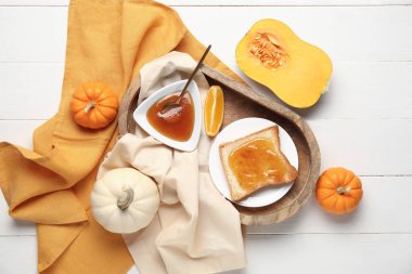 Tatlı kabak reçelli tost tabağı ve beyaz ahşap arka planda portakal.