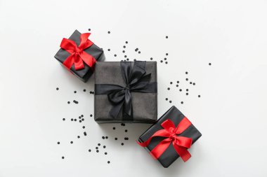 Beyaz arka planda hediye kutuları ve konfeti. Kara Cuma