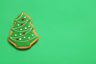 Yeşil arka planda Noel ağacı şeklinde lezzetli kurabiyeler.