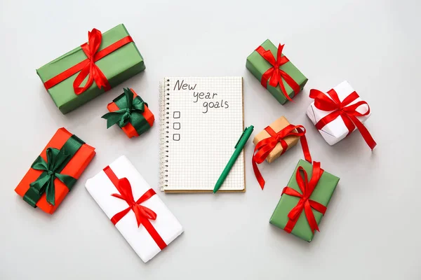 Notizbuch Mit Leerer Liste Stift Und Weihnachtsgeschenkboxen Auf Grauem Hintergrund — Stockfoto