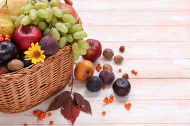Beyaz ahşap arka planda farklı taze meyvelerle dolu sepet.