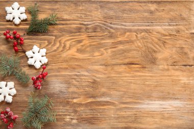 Köknar dalları ve kahverengi ahşap arka planda böğürtlenleri olan güzel kar taneleri