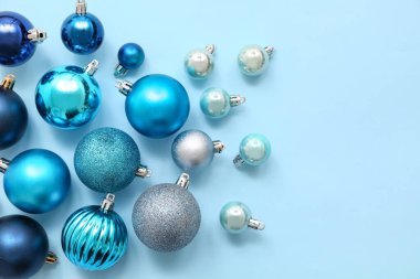 Mavi arka planda Noel topları olan kompozisyon