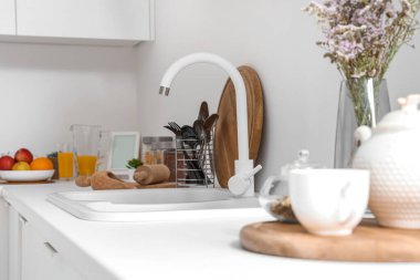 Modern mutfağın içinde lavabo ve çatal bıçak bulunan beyaz tezgahlar, yakın plan.