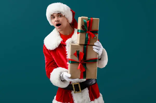 Shocked Santa Claus with gift boxes on dark green background