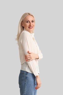 Mature blonde woman on light background