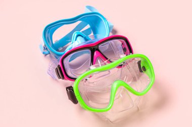 Pembe arka planda farklı yüzme maskeleri, yakın plan