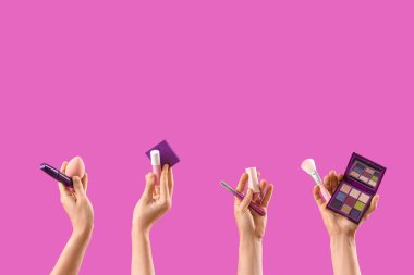 Pembe arka planda makyaj ürünleri olan kadınlar