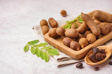 Tahta tahta ve beyaz arka planda lezzetli tamarindler.