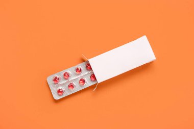 Sarı haplar turuncu arka planda su topladı.