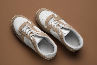 Kahverengi arka planda şık spor ayakkabılar