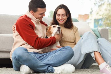 Evde sevimli Beagle köpeği olan genç bir çift.