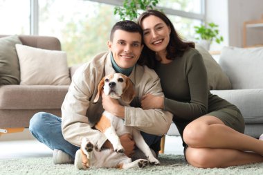 Evde sevimli Beagle köpeği olan genç bir çift.