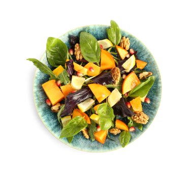 Bir tabak lezzetli salata, hurma, nar tohumu ve beyaz arka planda ceviz.