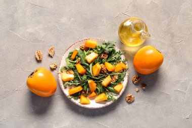 Gri arka planda ceviz ve hurma ile lezzetli bir salata.