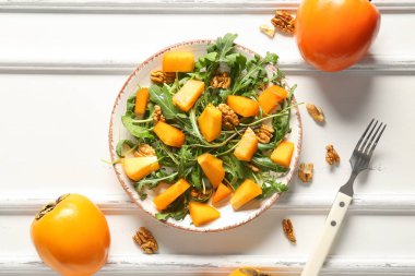 Beyaz zemin üzerinde hurma ve ceviz olan lezzetli bir salata tabağı.