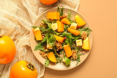 Bej arka planda hurma, ceviz ve nar tohumlu bir tabak lezzetli salata.