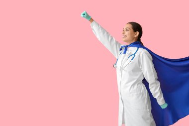 Pembe arka planda süper kahraman kostümlü güzel bayan doktor.