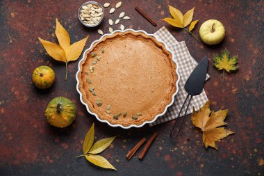 Kahverengi arka planda lezzetli balkabağı turtasıyla sonbahar kompozisyonu