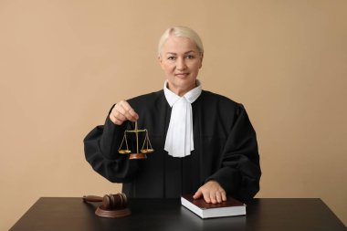 Adalet terazisi ve kahverengi arka plan kitabı olan olgun bir kadın yargıç.