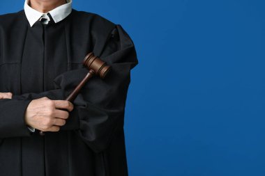 Çapraz kollu kadın yargıç ve mavi arka planda tokmak