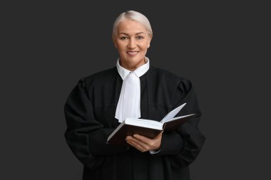 Siyah arka plan kitabı olan olgun bir kadın yargıç.