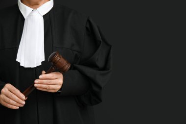 Siyah arka planda tokmağı olan kadın yargıç