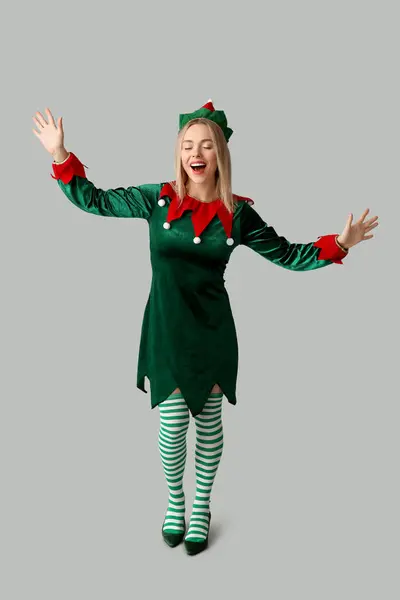 Young woman in elf costume on white background