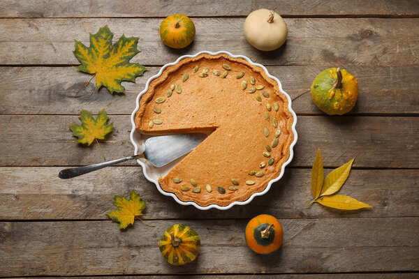 Осенняя композиция с вкусным тыквенным пирогом на деревянном фоне