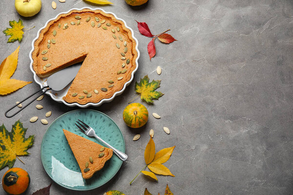 Осенняя композиция с вкусным тыквенным пирогом на сером фоне
