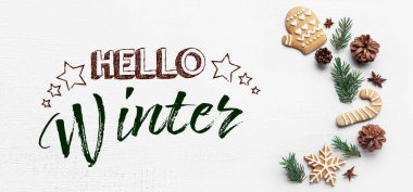 Firavun ağacı dalları, çam kozalakları ve beyaz ahşap arka planda Noel kurabiyeleri. Merhaba kış.