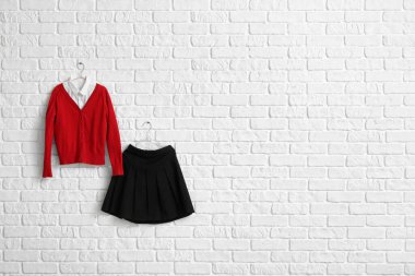 Odanın duvarında asılı şık bir okul üniforması.