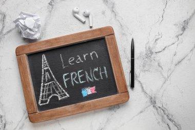 Yazı tahtası LeARN FRENCH, kulaklıklar, grunge arkaplan üzerine buruşuk kağıt
