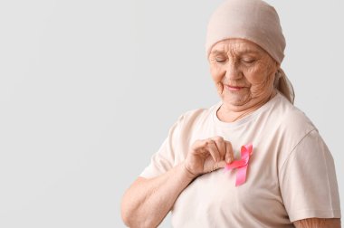 Yeşil arka planda pembe kurdeleli kemoterapiden sonra son sınıf öğrencisi. Göğüs kanseri kavramı