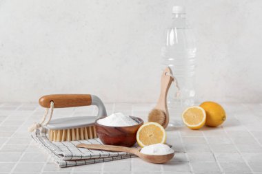 Bir kase kabartma tozu, sirke, temizlik fırçası, limon ve peçete.