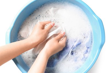 Beyaz arka planda izole edilmiş plastik leğende çamaşır yıkayan kadın.