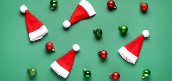 Noel Baba Şapkaları Noel Topları Yeşil Arka Planda Düz Yatıyordu — Stok fotoğraf