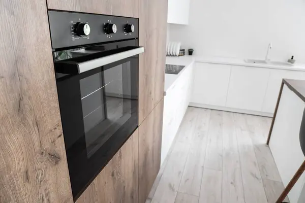 Wooden furniture with modern built-in oven in kitchen