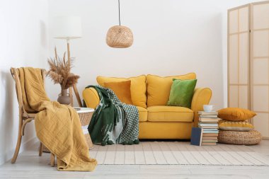 Oturma odası, kanepe, tabure ve ekoseli.