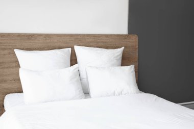 Konforlu çift kişilik yatak odası ve beyaz yastıklar.